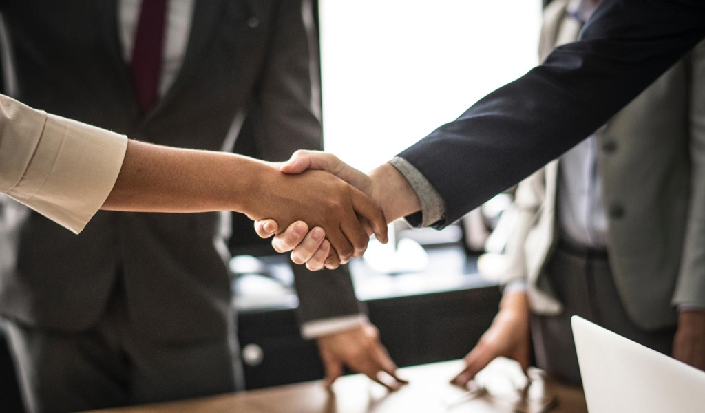 A picture of two persons shaking hands each other